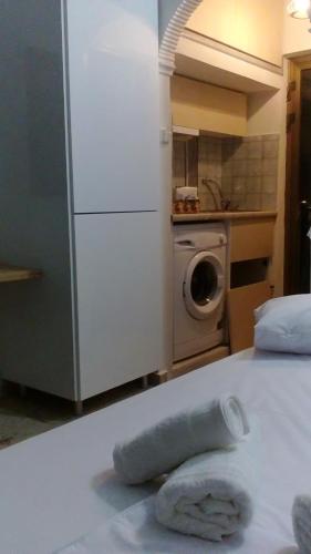 Una toalla en una cama en una cocina con nevera en agia marina riviera aigina, en Agia Marina Aegina
