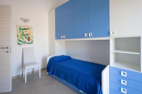 sypialnia z niebieskim łóżkiem i niebieskimi szafkami w obiekcie Nebrodi Park Private Villa w mieście SantʼAgata di Militello