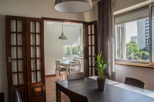 a dining room with a table and a large window at Typical Apartment in Lisbon, Campo Grande (Parking included) in Lisbon