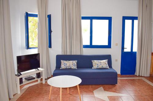salon z niebieską kanapą i stołem w obiekcie Muses seaside Villas w mieście Paralio Astros