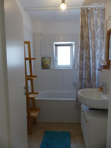 a bathroom with a bath tub and a sink at Ferienwohnung Gretl & Xaver in Neumarkt in der Oberpfalz