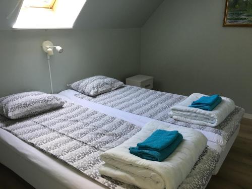 twee bedden in een kamer met handdoeken erop bij Statarlängan in Visby