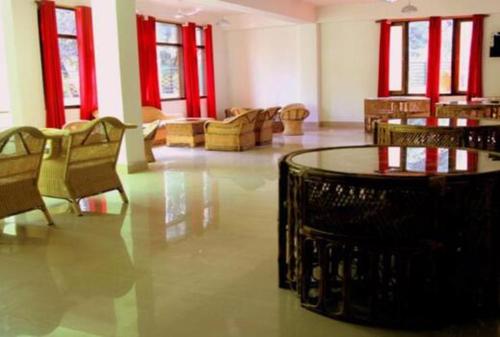 Vamoose Eco Paradise في Dzānak: غرفة كبيرة بها كراسي وطاولة ونوافذ حمراء