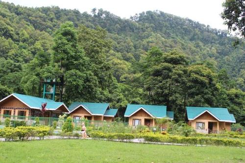 uma fila de casas com telhados azuis em frente a uma montanha em Vamoose Eco Paradise em Dzānak