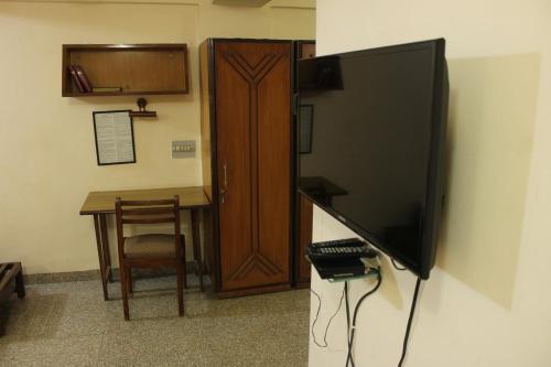 a flat screen tv hanging on a wall next to a table at YWCA International Centre in Mumbai