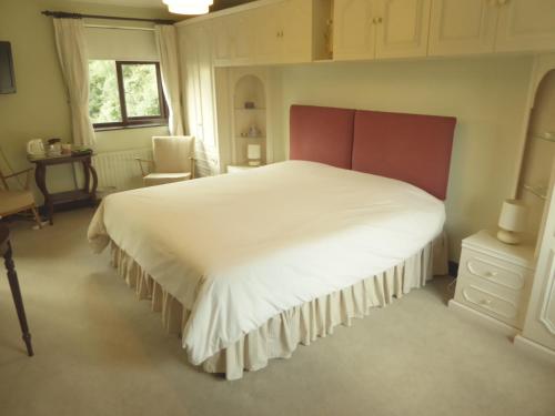 a bedroom with a large white bed and a chair at At Last Bed & Breakfast in Edlington