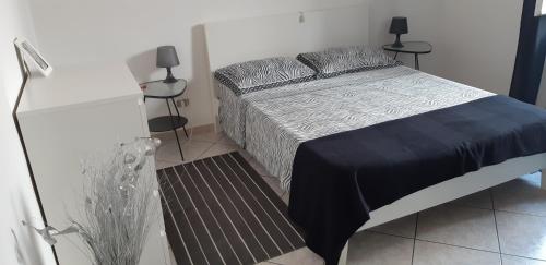 a bed in a bedroom with two tables and a bedskirtspectspectspectspects at Sleep And Fly Apartment in Pescara