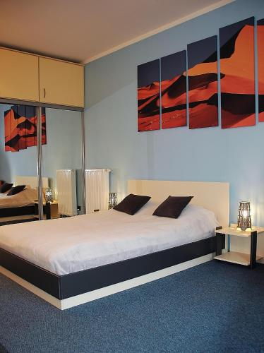 1 dormitorio con 1 cama grande con pinturas en la pared en Spacious apartment in the heart of Krakow, en Cracovia
