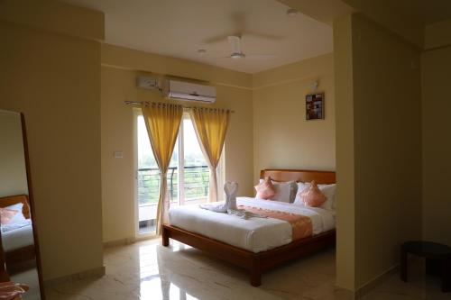 a bedroom with a bed and a window at Lali Petals in Madikeri