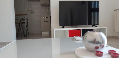 un soggiorno con TV e un vaso sul tavolo di Sleep And Fly Apartment a Pescara