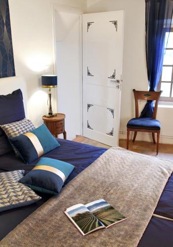 - une chambre avec un lit et un livre dans l'établissement Maison de Maître Des-Sens, à Nyons