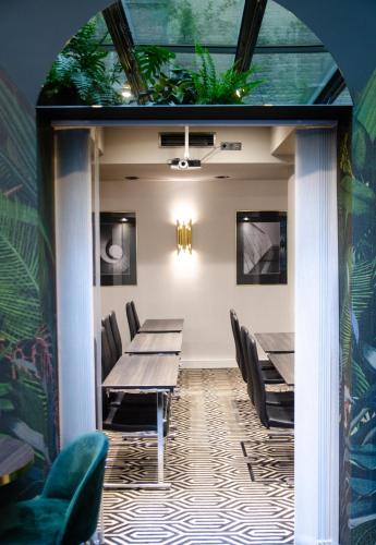a dining room with tables and chairs and plants at Hotel Atrium in Kraków