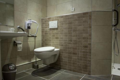 a bathroom with a toilet and a sink and a shower at Hôtel Karène in Saint-Paul-lès-Romans