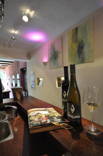 a bottle of wine sitting on a bar with a glass at Gästezimmer im Weingut Amlinger&Sohn in Neef