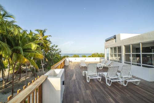 a deck with chairs and a table on a house at Portia Hotel & Spa in Dhiffushi