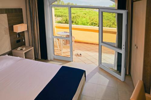 a bedroom with a bed and a view of a balcony at TUI MAGIC LIFE Calabria - All Inclusive in Pizzo