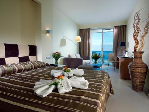 una camera d'albergo con un letto e asciugamani di El Greco Hotel a Ierápetra