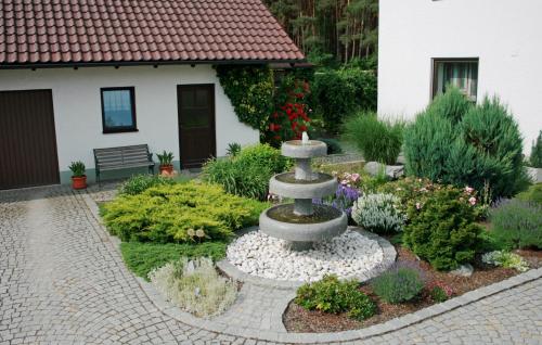 a garden with a fountain in front of a house at Ferienwohnung Maria in Nittenau