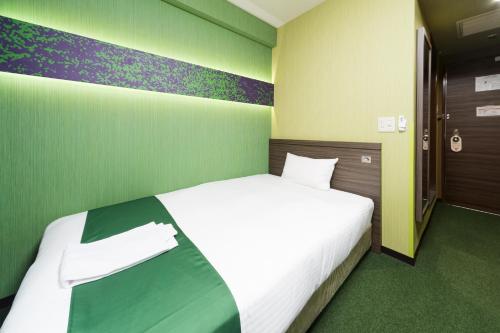 a bedroom with a bed in a green room at Hotel Wing International Nagoya in Nagoya