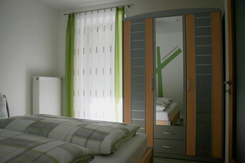 a bedroom with a bed and a dresser and a mirror at Ferienwohnung Maria in Nittenau