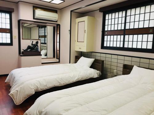 Vuode tai vuoteita majoituspaikassa Guesthouse & Hotel RA Kagoshima