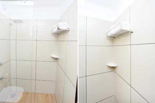 a bathroom with white walls and a glass shower at Sunstar Residency & Food Plaza Pala in Lālam