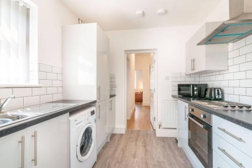 a kitchen with white cabinets and a washer and dryer at 1 Bed Apt with Free Parking East Hull Work or Leisure in Hull