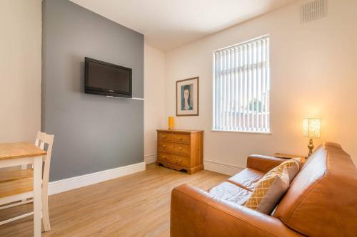 a living room with a couch and a television at PLATFORM Port Area Apartment 1 in Hull
