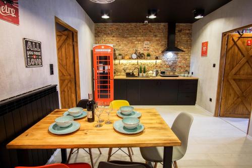 una mesa de madera con platos y una cabina de teléfono roja en Retro Apartments, en Rzeszów