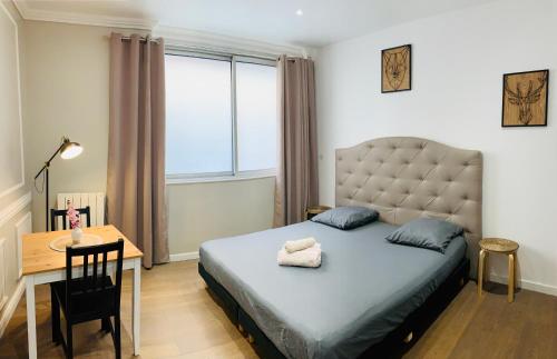a bedroom with a bed and a desk and a window at Victoire Appartement in Aix-en-Provence
