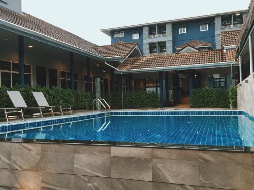 a swimming pool in front of a building at Blue Bed Hotel in Chanthaburi