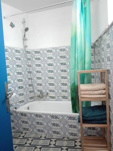 a bathroom with a shower and a tub and a chair at Casa Maritima in Aljezur