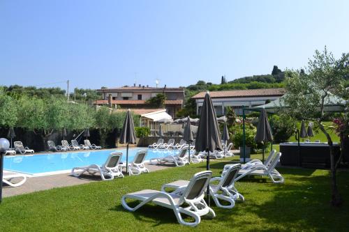 a group of chairs and umbrellas next to a pool at Hotel Mary Rose in Lazise