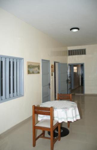a dining room with a table and two chairs at Quintal di Maria in Guediawaye