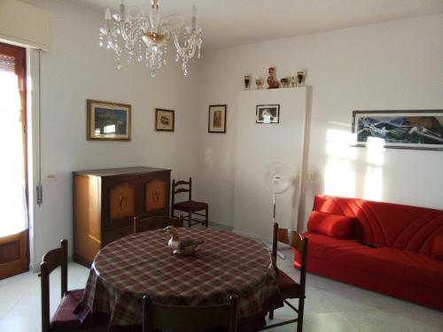 Casale ZappullaにあるCasa vacanze Don Peppinoのリビングルーム(テーブル、赤いソファ付)