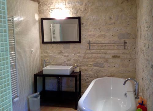 y baño con bañera, lavabo y espejo. en Villa Mas, en Cestayrols