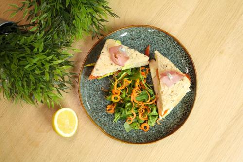 a plate of food with a sandwich and a salad at ibis Paris Bercy Village in Paris
