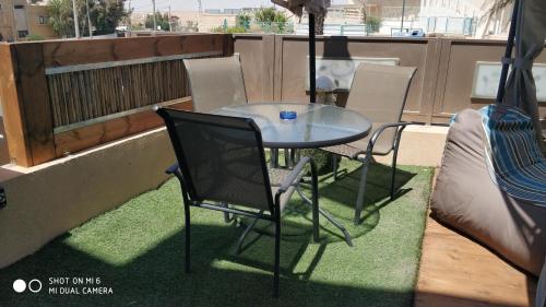 a table and chairs on a balcony with a bed at ARAD-DEAD SEA BASHIRIS PLACE in Arad