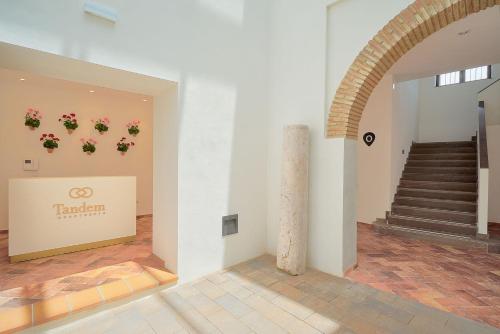 a room with a staircase and flowers on the wall at Tandem El Patio in Córdoba