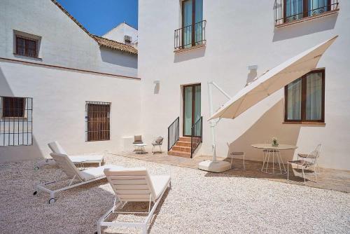 a patio with chairs and a table in a building at Tandem El Patio in Córdoba