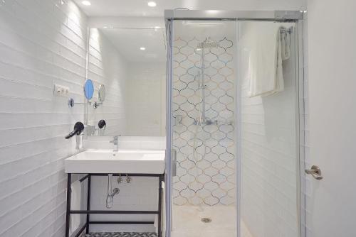 a white bathroom with a sink and a shower at Tandem El Patio in Córdoba