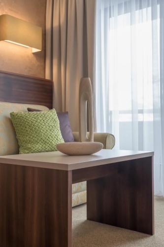 a bedroom with a bed with a desk and a window at Hotel Madeleine in Obergurgl