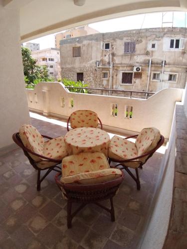 a balcony with chairs and a table and a window at Vacation Apartments in a Private Villa with Private Beach Access in Alexandria