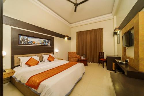 Habitación de hotel con cama y TV de pantalla plana. en Hotel H R Palace en Jaipur