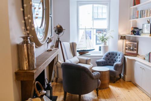 a living room with two chairs and a mirror at The Old Quay House Hotel in Fowey