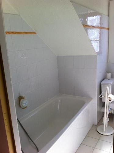 a bath tub in a bathroom with a toilet at Hotel Le Blanche Neige in Valberg