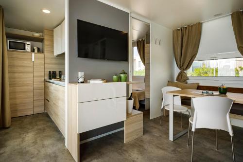 a small kitchen and dining room with a table and chairs at Amber Sea Luxury Village Mobile Homes in Novigrad Istria