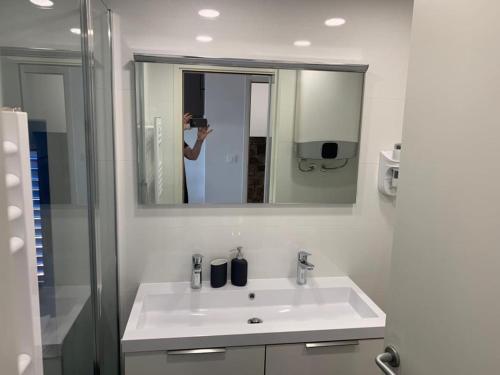 a person taking a picture of a bathroom sink at Penthouse in old Dalmatian house - Flybridge in Hvar