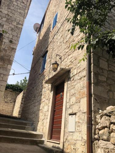 a stone building with a brown door and stairs at Penthouse in old Dalmatian house - Flybridge in Hvar