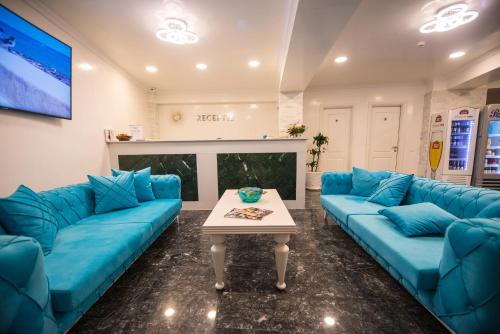 a living room with blue couches and a table at Hotel Meduza Estival in Olimp